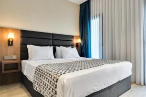 a bedroom with a large bed with a black headboard at Eleven Inn Tbilisi in Tbilisi City