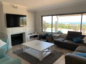 a living room with a couch and a tv at 56 Robberg Road Plettenberg Bay in Plettenberg Bay