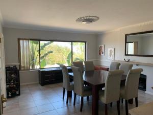 a dining room with a table and chairs and a window at 56 Robberg Road Plettenberg Bay in Plettenberg Bay