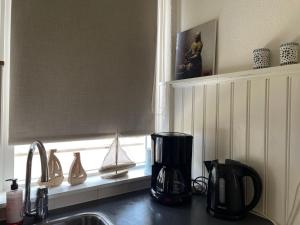 Una encimera de cocina con un fregadero y una ventana. en Me Oissie, en Egmond aan Zee