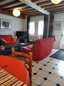 a living room with a red chair and a couch at La Solitaire in Saint-Jean-aux-Bois