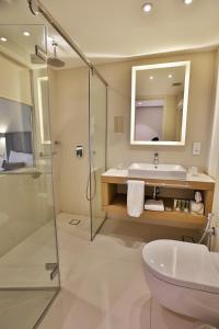 a bathroom with a sink and a toilet and a shower at AlQasr Metropole Hotel in Amman
