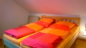 1 Schlafzimmer mit 2 Betten und bunter Bettwäsche in der Unterkunft Finke-Ferienhaus - OG in Grömitz
