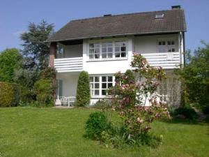 ein weißes Haus mit einem Busch im Hof in der Unterkunft Finke-Ferienhaus - OG in Grömitz