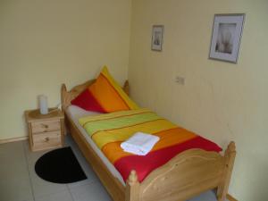 um quarto com uma cama de madeira e um cobertor colorido em Eifelferienhaus Thome em Lissendorf