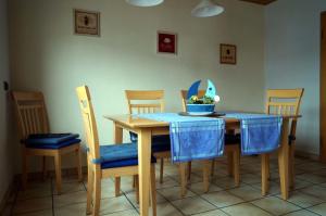 uma mesa de jantar com uma toalha de mesa azul e cadeiras em Eifelferienhaus Thome em Lissendorf