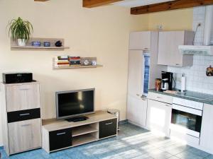 a kitchen with a tv on a wooden stand at Ihrgistern, FW 1 in Zingst