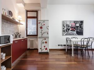 eine Küche mit einem Tisch und einem Kühlschrank in der Unterkunft MilanRentals - Vigliani Apartments in Mailand