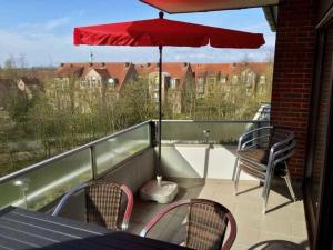 a balcony with a table and chairs and an umbrella at Appartment 40 in Tossens in Butjadingen OT Tossens