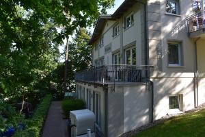 a white house with a balcony on the side of it at Villa Carina "Carina`s 912" in Baabe