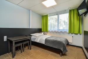 Schlafzimmer mit einem Bett, einem Tisch und einem TV in der Unterkunft City Yard Inn Hotel in Tallinn