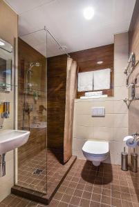 a bathroom with a toilet and a shower and a sink at City Yard Inn Hotel in Tallinn