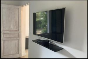 TV de pantalla plana colgada en la pared en Domaine Cassevinha, en Gauriac