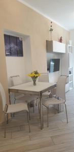 a dining room table and chairs with a vase of flowers on it at Karina House-check in H 24 in Como