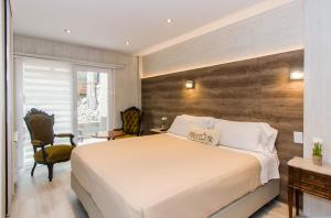 una camera con un grande letto e una parete in legno di Ushuaia Drake Departamentos a Ushuaia
