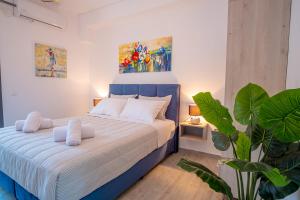 una camera con un letto blu e bianco con una pianta di Serenity Luxe Suites a Párga