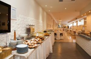 a buffet line in a restaurant with food on display at Hotel Madera in Lido di Jesolo