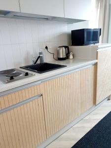 a kitchen counter with a sink and a stove at Apartamenty Loft Rooms - centrum, bezpłatny parking in Ełk