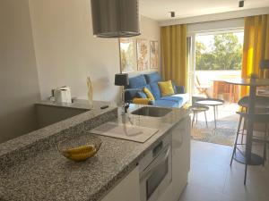 a kitchen with a counter top and a living room at Duplex de lujo Marbella- Dunas de Artola in Marbella