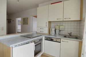 a kitchen with white cabinets and a sink at Hausherr, Herbert FW 22 in Zingst