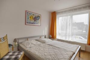 a bedroom with a bed and a large window at Hausherr, Herbert FW 22 in Zingst