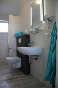 a bathroom with a sink and a toilet at Meerblick Fehmarnsund 2 - direkt am Strand in Fehmarnsund