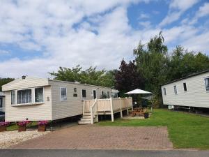 a couple of mobile homes parked in a yard at Relaxing Breaks with Hot tub at Tattershal lakes 3 Bedroom in Tattershall