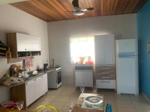 a kitchen with a white refrigerator and a table at Singela Casa em Chapada dos Guimarães in Chapada dos Guimarães +21 photos