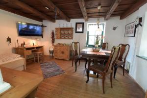 uma sala de jantar com uma mesa e cadeiras e uma televisão em Landhaus Nitsch em Prinzendorf an der Zaya