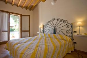 a bedroom with a bed with a yellow and white comforter at Villino Francesca in Portoferraio