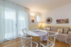 a living room with a table and a couch at APPARTAMENTO VILLAGGIO CASCINA - JESOLO in Lido di Jesolo