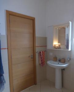 a bathroom with a wooden door and a sink at Meeresrauschen auf Kreol in Sal Rei
