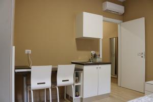 una cocina con armarios blancos y taburetes blancos en Smart Flat Portello, en Milán