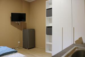 Habitación con nevera y TV en la pared. en Smart Flat Portello, en Milán