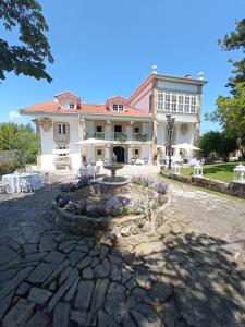 a large house with a fountain in front of it at Hosteria de Arnuero in Arnuero