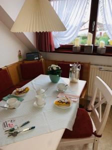 une table blanche avec des assiettes de nourriture dans l'établissement Haus Boy Jensen "Dünenblick", à Wenningstedt