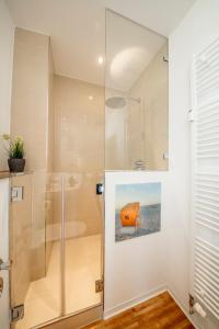 a shower with a glass door in a bathroom at Strandburg Azurblau in Burgtiefe auf Fehmarn 