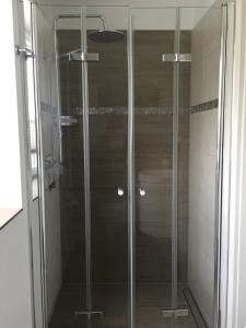 a shower with glass doors in a bathroom at Ferienwohnung Marschall in Heiligenhafen