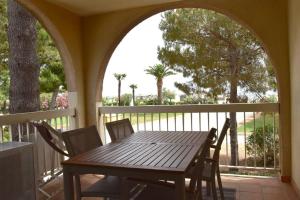 y balcón con mesa y sillas de madera. en Le Byblos 7, en Argelès-sur-Mer