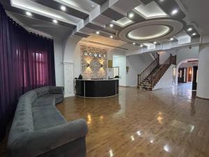ein großes Wohnzimmer mit Sofa und Bühne in der Unterkunft Al Arda Avenue in Taschkent