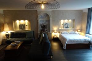a bedroom with a bed and a living room with a couch at La Halte in Jeuxey