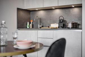 cocina con mesa, fregadero y encimera en BRIGHT Augsburg-Altstadt, en Augsburg