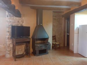 a living room with a stove and a tv at CASA VICENT in Valderrobres