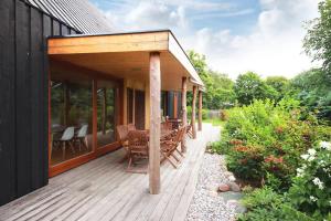 a wooden deck with a table and chairs on a house at Loi Black in Loissin