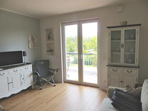 een woonkamer met een tv en een glazen schuifdeur bij Dorothee V6W5 in Dierhagen