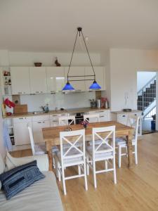 eine Küche und ein Esszimmer mit einem Holztisch und Stühlen in der Unterkunft Dorothee V6W5 in Dierhagen
