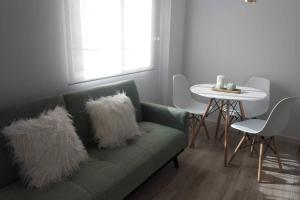 uma sala de estar com um sofá verde com almofadas de pele falsas em Precioso apartamento en San Juan de Alicante em San Juan de Alicante