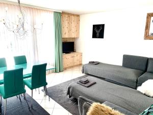 a living room with a couch and a table and chairs at Holiday Apartment Gian - close to the Kongresshaus, the ice hockey stadium, cross-country skiing, the Eau-la-la indoor pool and wellness, large supermarket, 2 bus stops, with an indoor garage and fully equipped in Davos