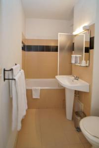 y baño con lavabo, bañera y aseo. en Hôtel Amaya, en Ambarès-et-Lagrave