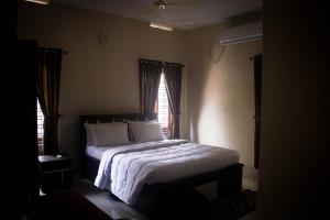 Schlafzimmer mit einem Bett mit weißer Bettwäsche und einem Fenster in der Unterkunft Maliyakal Homestay in Ernakulam